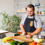 8 Ways You Can Reduce or Stop Hair Loss: Hero Image 8 Ways You Can Reduce or Stop Hair Loss, featuring tips like gentle hair care and a healthy diet, displayed next to a man chopping fresh vegetables in a bright kitchen, following a recipe from his laptop.