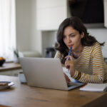 Choosing the Best Birth Control Pill: The Ultimate Guide: Hero Image A woman researching birth control options on her laptop, comparing different choices to determine which one is the best fit for her health and lifestyle.